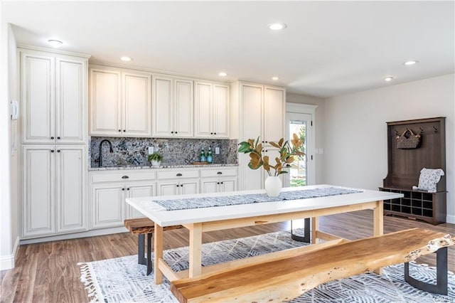 55606 Rd 226, North Fork, CA 93643 - kitchen featuring decorative backsplash, light wood-type flooring, recessed lighting, a sink, and white cabinetry