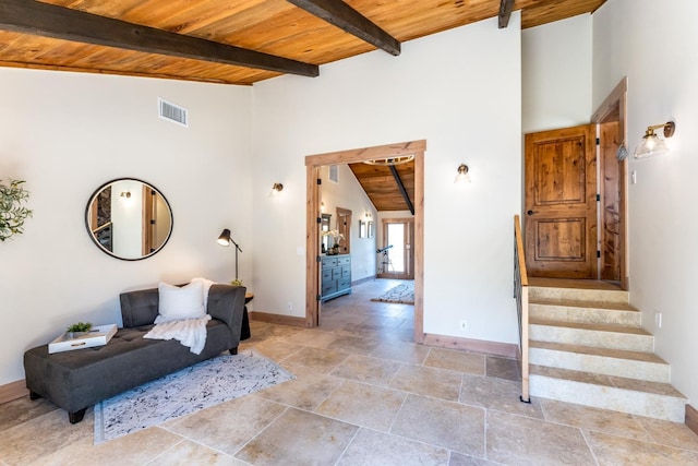55606 Rd 226, North Fork, CA 93643 - sitting room with wooden ceiling with exposed beams, baseboards, high vaulted ceiling, light stone finish floors, and stairs