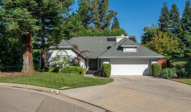 9109 N Chadwick Ln, Fresno, CA 93720 - view of front facade featuring a garage, driveway, a front yard, roof with shingles, and a chimney