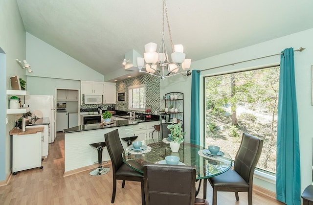 38830 Littlefield Rd, Shaver Lake, CA 93664 - dining room with a chandelier, light wood-style flooring, and vaulted ceiling