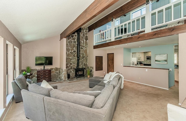 38830 Littlefield Rd, Shaver Lake, CA 93664 - carpeted living room featuring a wood stove, healthy amount of natural light, baseboards, a textured ceiling, and high vaulted ceiling