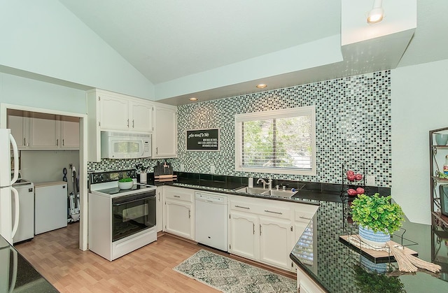 38830 Littlefield Rd, Shaver Lake, CA 93664 - kitchen featuring white appliances, a sink, dark countertops, vaulted ceiling, and tasteful backsplash