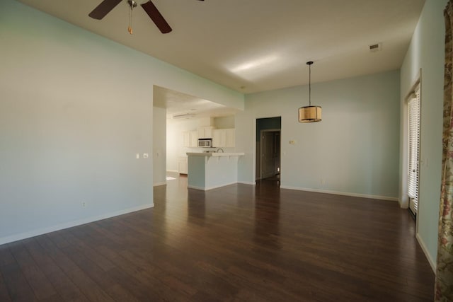 5138 W Beechwood Ave, Fresno, CA 93722 - unfurnished living room featuring dark wood finished floors, ceiling fan, and baseboards