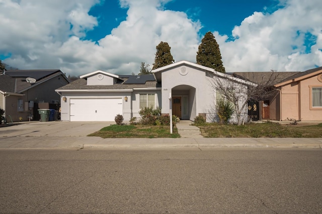 5138 W Beechwood Ave, Fresno, CA 93722 - ranch-style house with stucco siding, solar panels, concrete driveway, and an attached garage