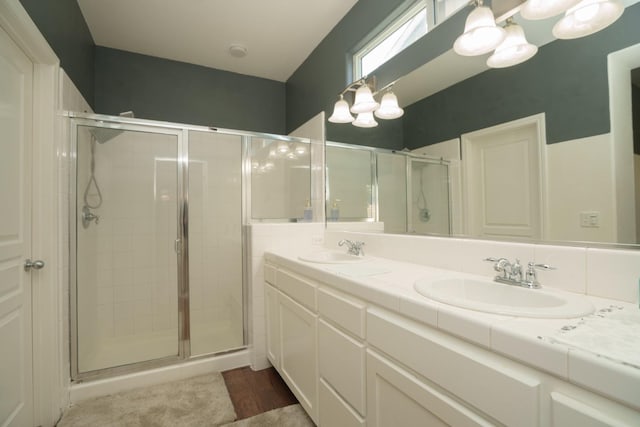 5138 W Beechwood Ave, Fresno, CA 93722 - bathroom with a shower stall, double vanity, and wood finished floors
