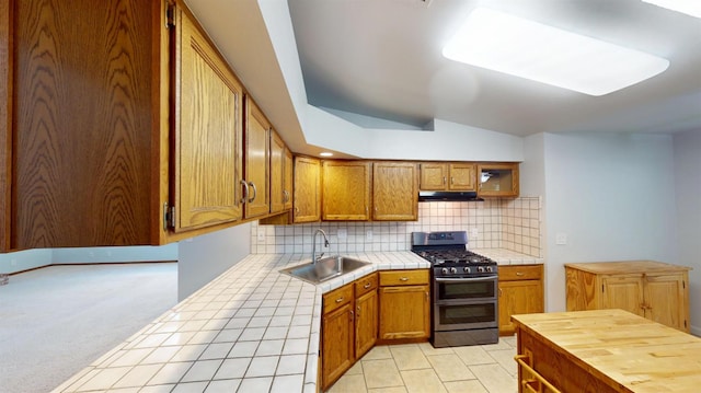 1604 W Central Ave, Madera, CA 93637 - kitchen with stainless steel range with gas cooktop, tile countertops, under cabinet range hood, decorative backsplash, and brown cabinetry