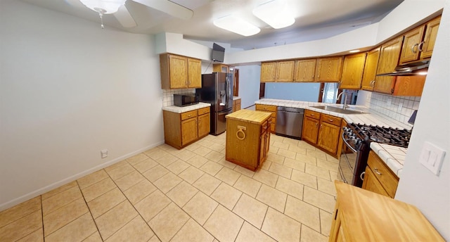 1604 W Central Ave, Madera, CA 93637 - kitchen featuring appliances with stainless steel finishes, a sink, tasteful backsplash, under cabinet range hood, and brown cabinets