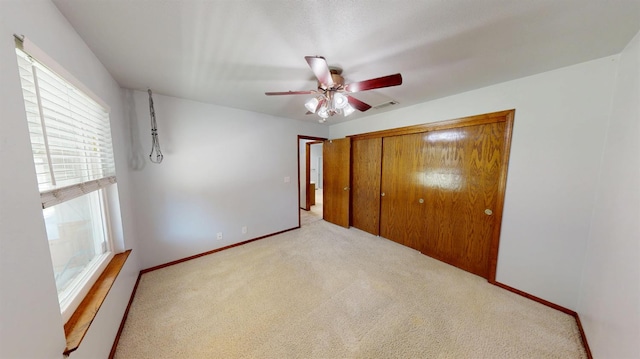 1604 W Central Ave, Madera, CA 93637 - unfurnished bedroom featuring multiple windows, carpet floors, a closet, and baseboards