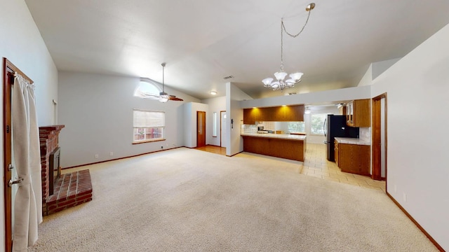 1604 W Central Ave, Madera, CA 93637 - kitchen with a chandelier, freestanding refrigerator, lofted ceiling, brown cabinets, and light countertops