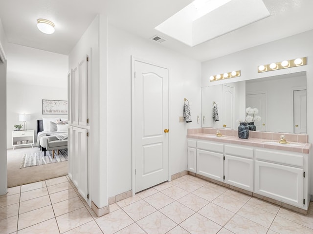 7549 N 8th, Fresno, CA 93720 - ensuite bathroom featuring a skylight, double vanity, and tile patterned floors