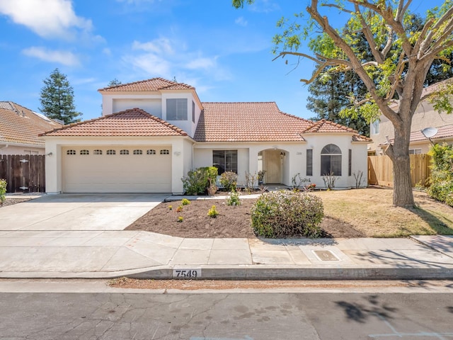 7549 N 8th, Fresno, CA 93720 - mediterranean / spanish home with stucco siding, a tiled roof, and an attached garage
