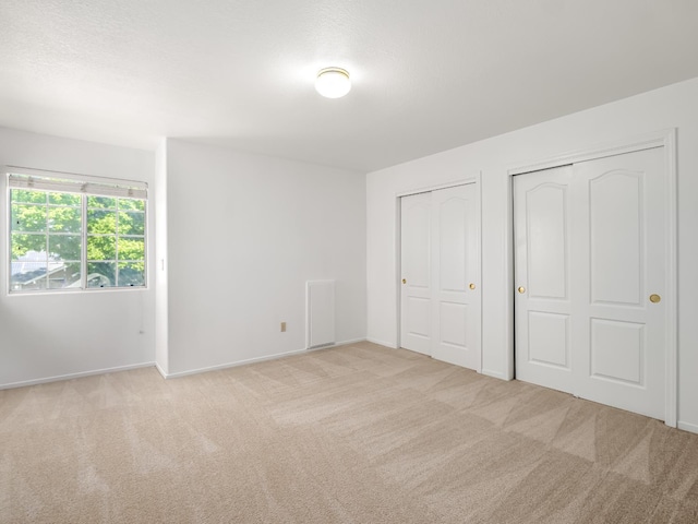 7549 N 8th, Fresno, CA 93720 - unfurnished bedroom with multiple closets, carpet flooring, and baseboards