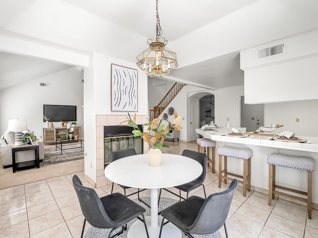 7549 N 8th, Fresno, CA 93720 - dining area featuring arched walkways, vaulted ceiling, stairs, light tile patterned floors, and a chandelier