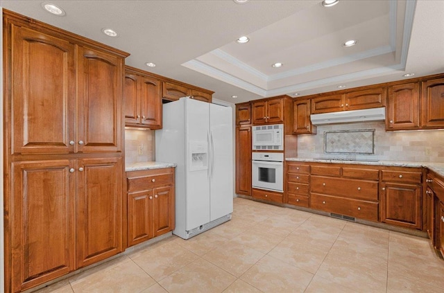 3595 W Magill Ave, Fresno, CA 93711 - kitchen featuring white appliances, under cabinet range hood, a tray ceiling, brown cabinetry, and recessed lighting