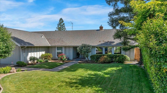 3595 W Magill Ave, Fresno, CA 93711 - view of front of home featuring board and batten siding, a front lawn, a chimney, and a shingled roof