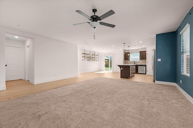 2520 S Spruce St, Visalia, CA 93292 - unfurnished living room featuring light colored carpet, ceiling fan, baseboards, recessed lighting, and a sink