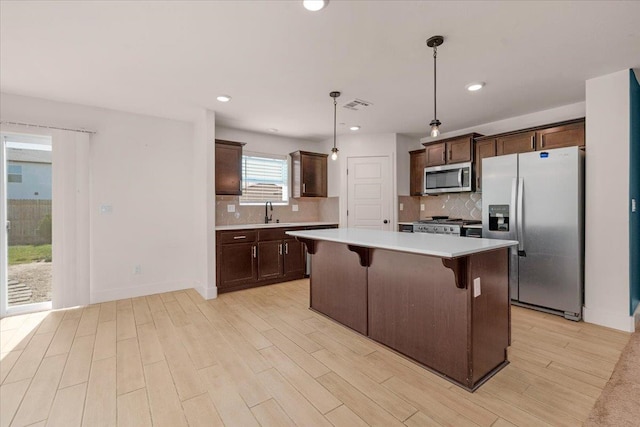 2520 S Spruce St, Visalia, CA 93292 - kitchen featuring stainless steel appliances, light countertops, tasteful backsplash, dark brown cabinetry, and light wood-style flooring
