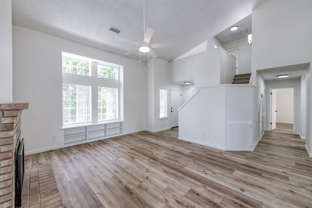1892 E Goshen Ave, Fresno, CA 93720 - unfurnished living room with a fireplace, ceiling fan, wood finished floors, high vaulted ceiling, and baseboards