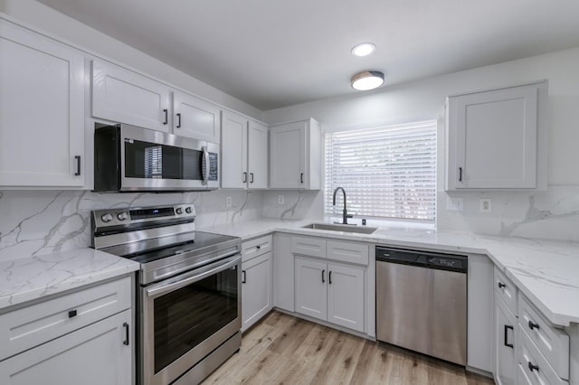 1892 E Goshen Ave, Fresno, CA 93720 - kitchen with stainless steel appliances, a sink, decorative backsplash, and white cabinetry