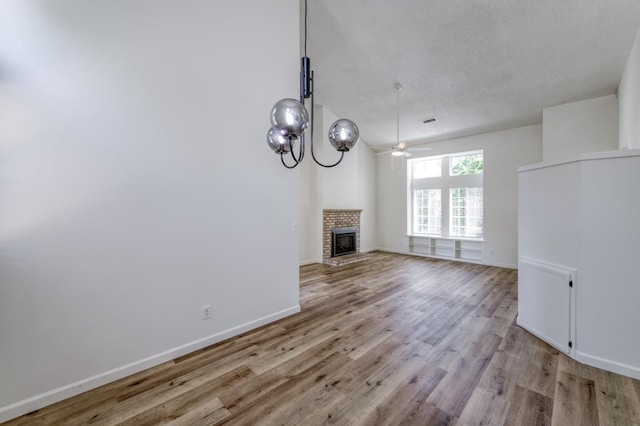 1892 E Goshen Ave, Fresno, CA 93720 - unfurnished living room featuring light wood-style floors, a ceiling fan, baseboards, and a fireplace