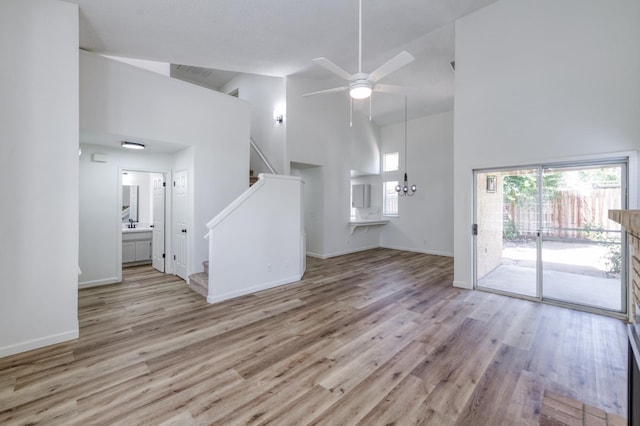 1892 E Goshen Ave, Fresno, CA 93720 - unfurnished living room featuring high vaulted ceiling, stairway, ceiling fan, wood finished floors, and baseboards