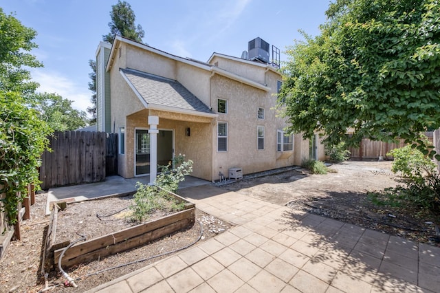 1892 E Goshen Ave, Fresno, CA 93720 - rear view of property with stucco siding, a patio area, central air condition unit, a vegetable garden, and roof with shingles