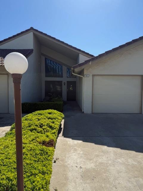 5749 N Monte Ave Unit 2, Fresno, CA 93711 - view of front facade featuring stucco siding, driveway, and a garage