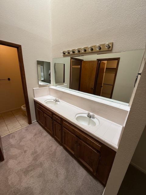5749 N Monte Ave Unit 2, Fresno, CA 93711 - bathroom with double vanity, toilet, tile patterned floors, and a textured wall