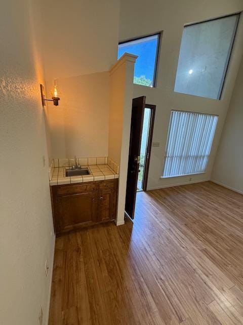 5749 N Monte Ave Unit 2, Fresno, CA 93711 - kitchen featuring tile countertops, a sink, wood finished floors, and brown cabinets