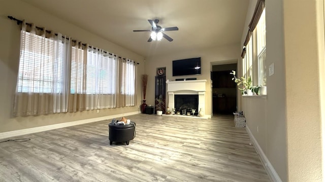3257 Twain Ave, Clovis, CA 93619 - unfurnished living room with ceiling fan, baseboards, wood finished floors, and a fireplace with raised hearth