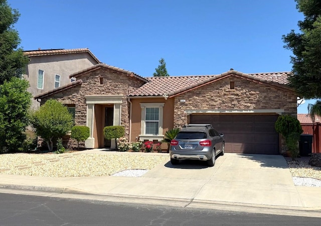3257 Twain Ave, Clovis, CA 93619 - mediterranean / spanish home with stone siding, a tile roof, a garage, concrete driveway, and stucco siding
