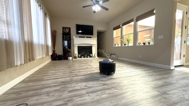 3257 Twain Ave, Clovis, CA 93619 - unfurnished living room with baseboards, ceiling fan, wood finished floors, and a fireplace with raised hearth