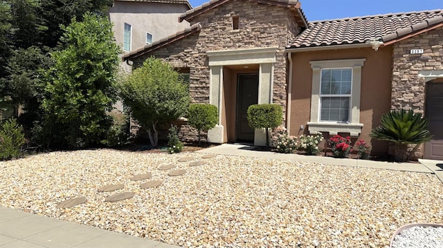 3257 Twain Ave, Clovis, CA 93619 - view of front of house with a tile roof, stone siding, stucco siding, and an attached garage