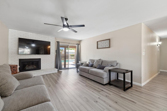 2051 E Fremont, Fresno, CA 93710 - living room featuring a ceiling fan, light wood-type flooring, a brick fireplace, and baseboards