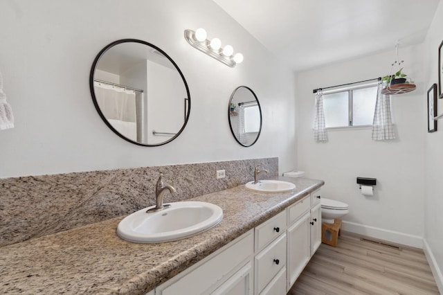 2051 E Fremont, Fresno, CA 93710 - full bath with double vanity, toilet, baseboards, and wood finished floors