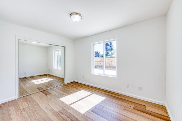 5164 W Michigan Ave, Fresno, CA 93722 - unfurnished bedroom with multiple windows, wood finished floors, baseboards, and a closet
