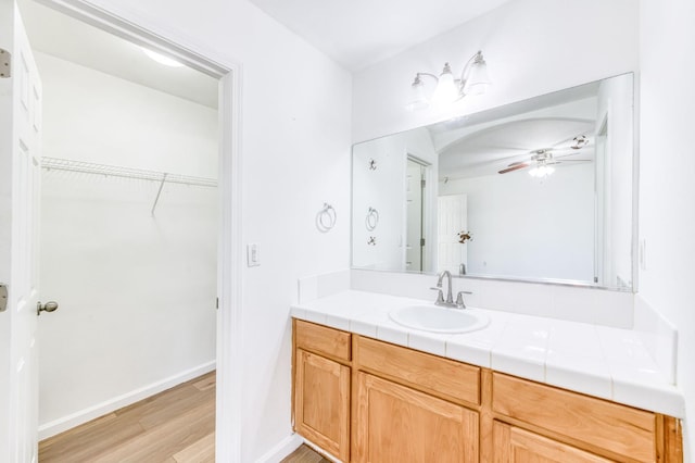 5164 W Michigan Ave, Fresno, CA 93722 - bathroom with vanity, wood finished floors, a ceiling fan, a walk in closet, and baseboards