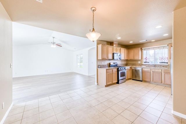 5164 W Michigan Ave, Fresno, CA 93722 - kitchen with stainless steel appliances, light brown cabinetry, plenty of natural light, lofted ceiling, and recessed lighting