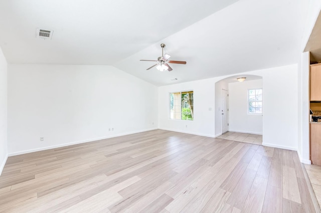 5164 W Michigan Ave, Fresno, CA 93722 - unfurnished living room with ceiling fan, arched walkways, light wood-style flooring, vaulted ceiling, and baseboards