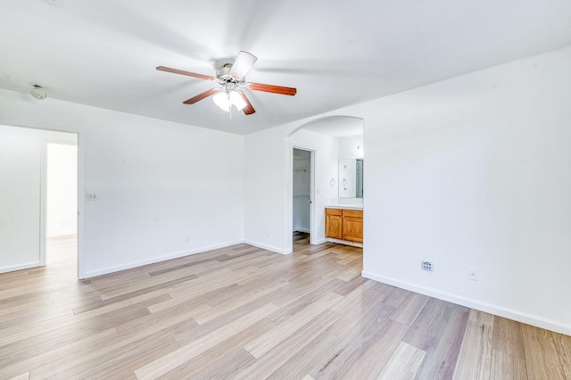 5164 W Michigan Ave, Fresno, CA 93722 - spare room featuring ceiling fan, light wood-style flooring, arched walkways, and baseboards