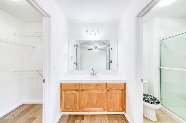 5164 W Michigan Ave, Fresno, CA 93722 - bathroom with wood finished floors, vanity, a shower stall, toilet, and a spacious closet