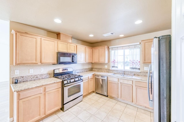 5164 W Michigan Ave, Fresno, CA 93722 - kitchen featuring light brown cabinets, stainless steel appliances, a sink, light tile patterned floors, and light stone counters