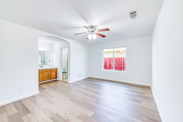 5164 W Michigan Ave, Fresno, CA 93722 - unfurnished bedroom with arched walkways, light wood-type flooring, and baseboards