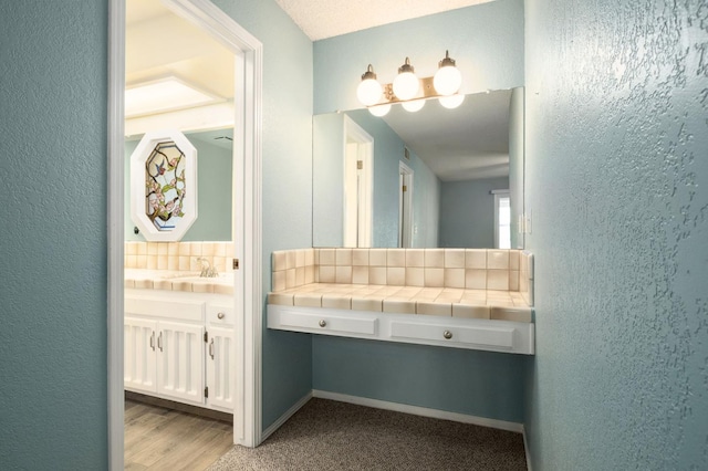 2081 Santa Ana Ave, Clovis, CA 93611 - bathroom featuring a textured wall, vanity, and decorative backsplash