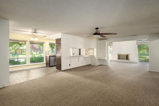 2081 Santa Ana Ave, Clovis, CA 93611 - unfurnished living room featuring a ceiling fan, carpet floors, a textured ceiling, baseboards, and a glass covered fireplace