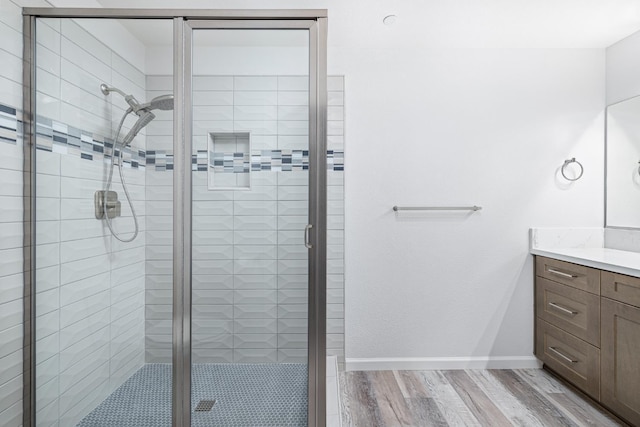 3752 N Augusta St, Fresno, CA 93726 - bathroom featuring vanity, wood finished floors, a stall shower, and baseboards