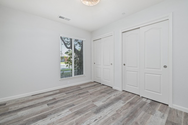 3752 N Augusta St, Fresno, CA 93726 - unfurnished bedroom featuring multiple closets, wood finished floors, and baseboards