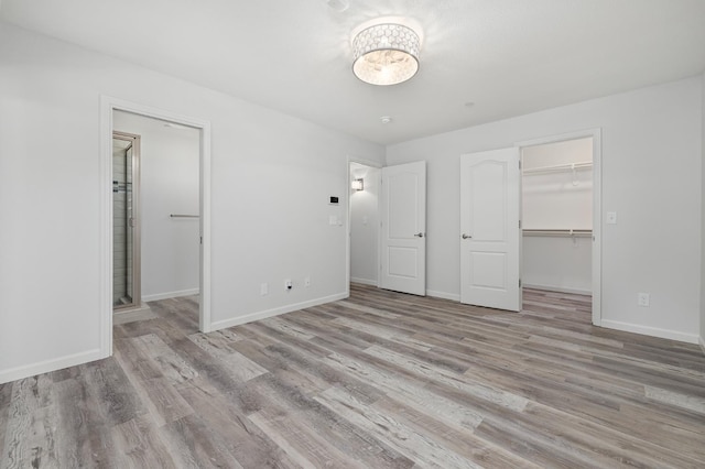 3752 N Augusta St, Fresno, CA 93726 - unfurnished bedroom with a walk in closet, a closet, wood finished floors, and baseboards