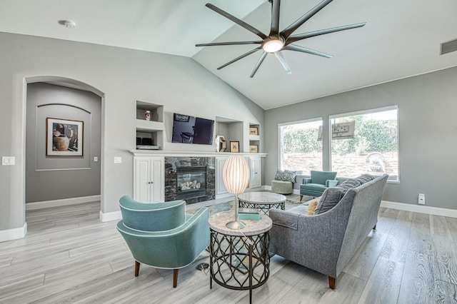 3081 Serena Ave, Clovis, CA 93619 - living area featuring ceiling fan, built in shelves, a fireplace, wood finished floors, and arched walkways