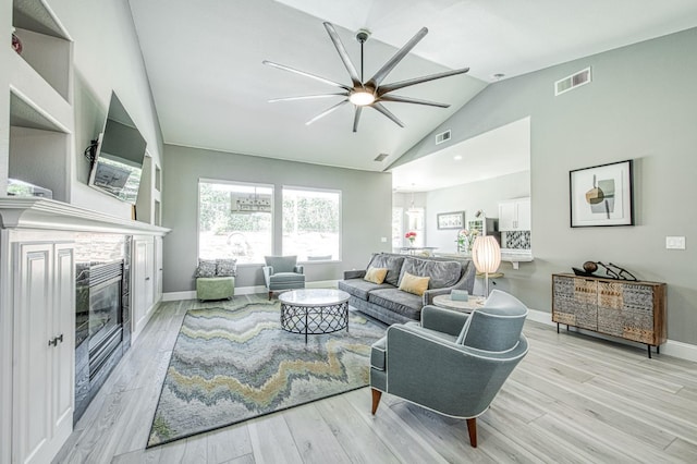 3081 Serena Ave, Clovis, CA 93619 - living area featuring ceiling fan, vaulted ceiling, light wood-type flooring, and a glass covered fireplace